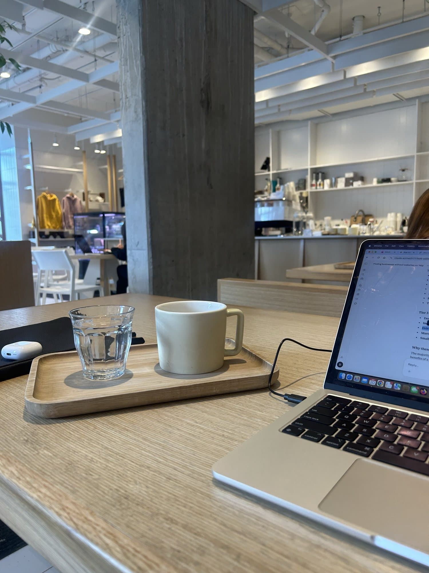 A coffee and laptop at a bright café workspace