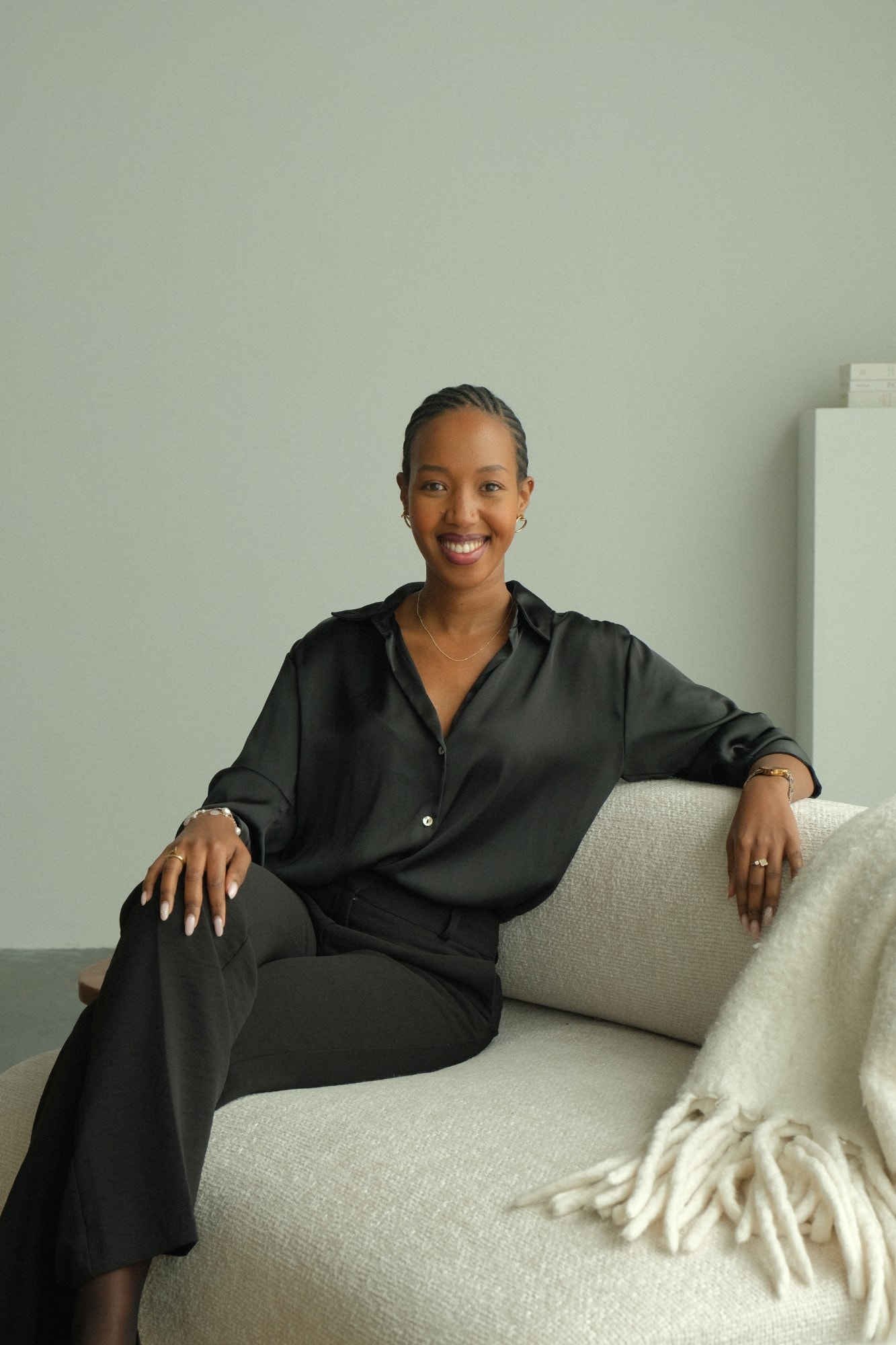 Davina Agasaro seated on a cream sofa, smiling